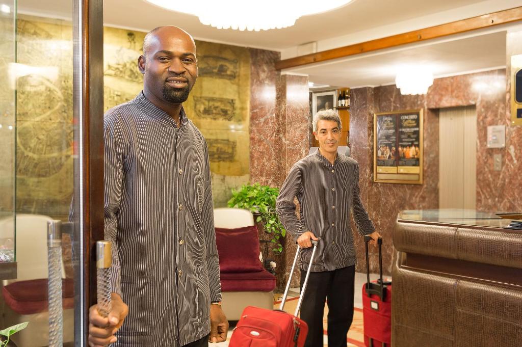 two people standing in a room with luggage at Hotel Montecarlo in Venice