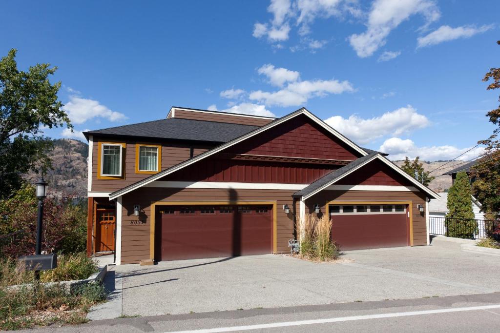 a house with two garage doors and a driveway at OKeefes Landing Bed & Breakfast in Vernon