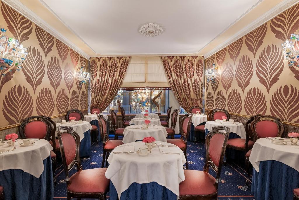a dining room with tables and chairs with white table cloth at Hotel Montecarlo in Venice