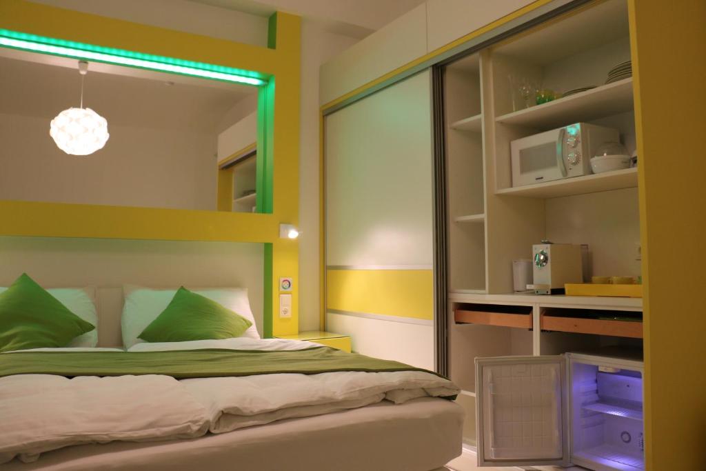 een slaapkamer met een bed met groene kussens bij CH-Hotel Luka in Wenen