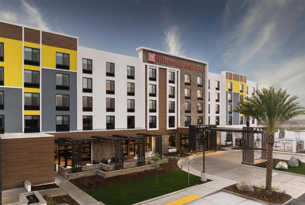 a rendering of a hotel building with a courtyard at Hilton Garden Inn Merced in Merced