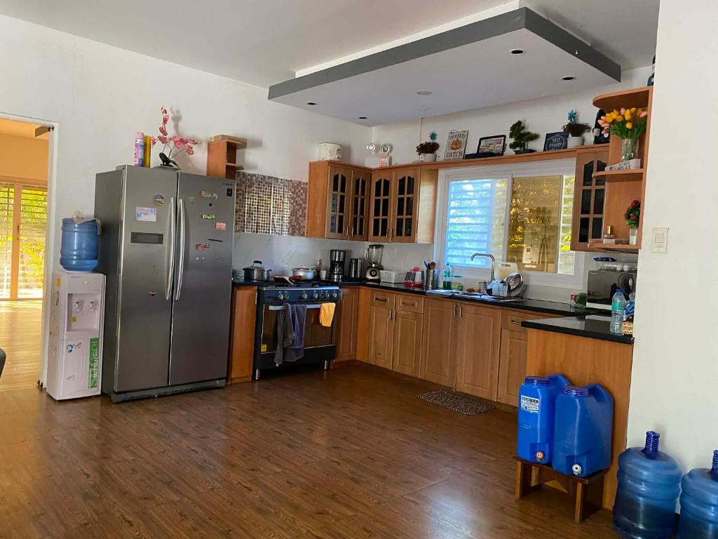 a kitchen with stainless steel appliances and wooden cabinets at CasaOlivia in Puerto Galera