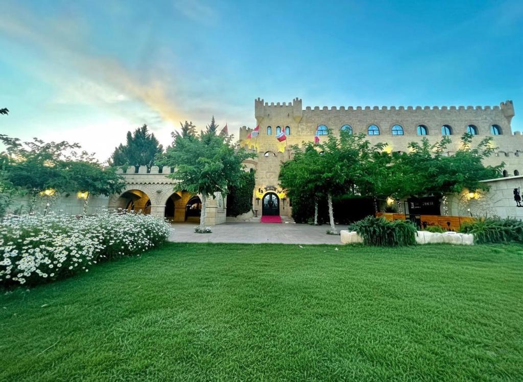 a large building with a green lawn in front of it at Hotel Castillo Bonavía in Pedrola