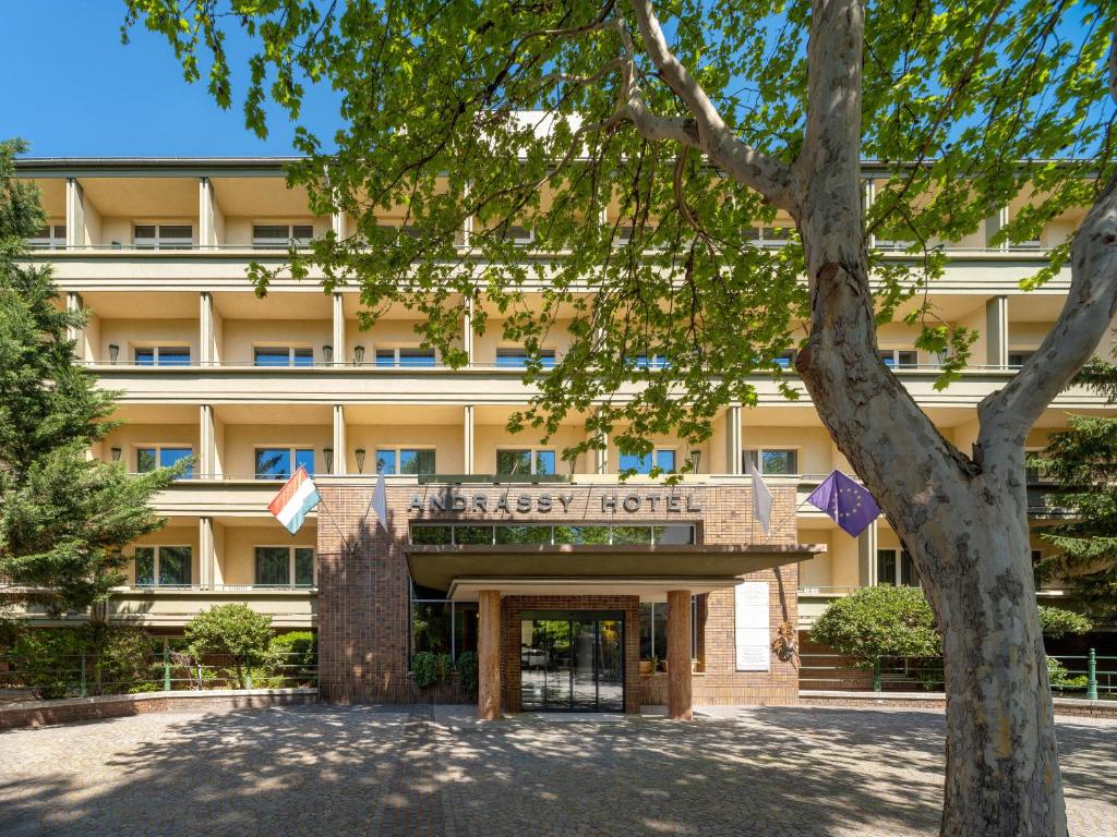 an office building with a tree in front of it at Mamaison Hotel Andrassy Budapest in Budapest