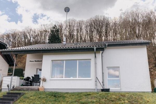 a small white house with a lot of windows at Ferienhaus Waldzeit in Heimbach