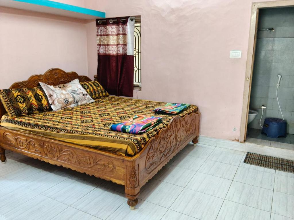 a bedroom with a wooden bed in a room at Sumathinandanakuteer in Pithāpuram