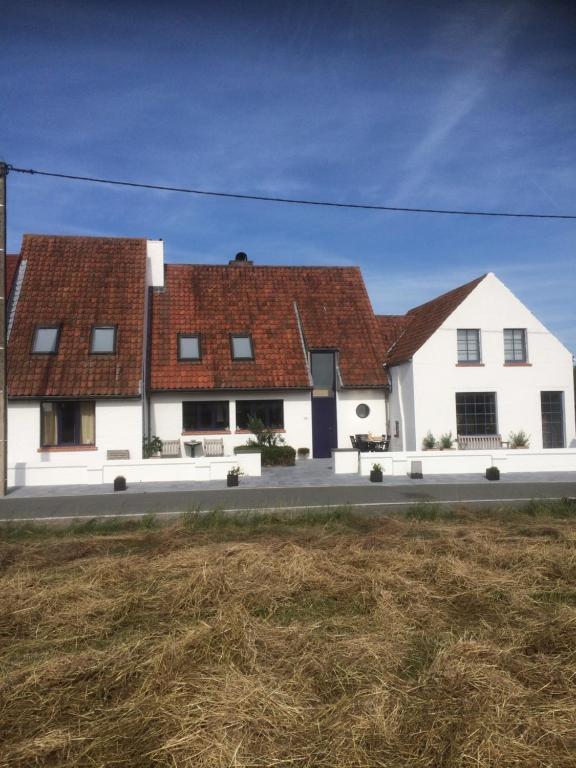 une maison blanche avec un toit rouge dans l'établissement Holiday Home Denolijfboom, au Coq