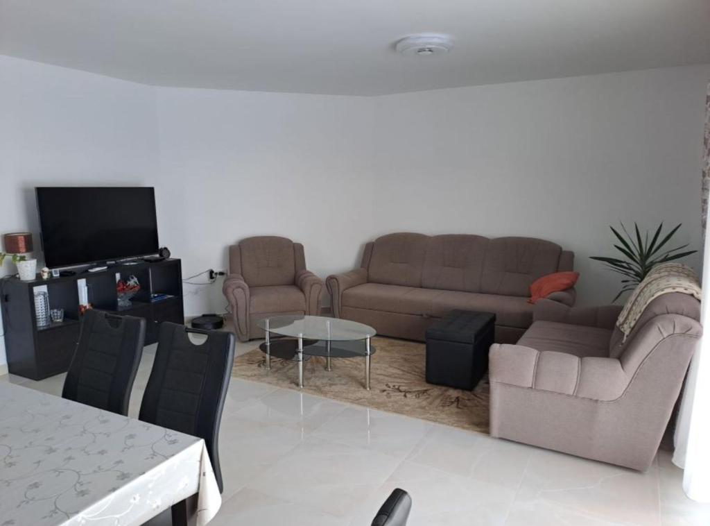a living room with two couches and a tv at Apartment Freya in Zadoborje