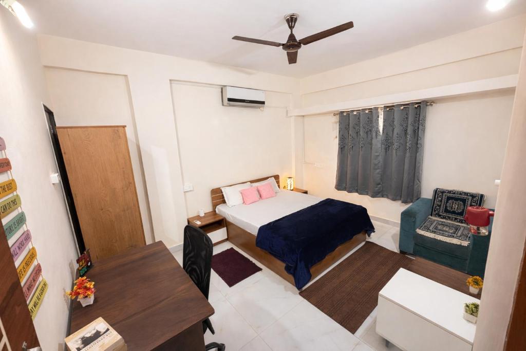 a small room with a bed and a chair at The Calm Courtyard- Pune in Pune