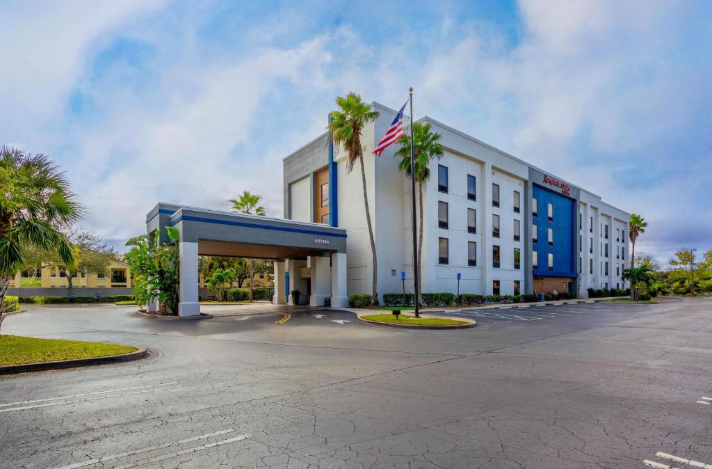 a hotel with palm trees in front of a building at Hampton Inn & Suites Port St. Lucie in Port Saint Lucie