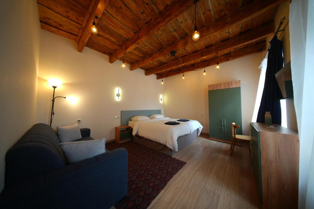 a bedroom with a bed and a couch in a room at Castle Gyumri in Gyumri