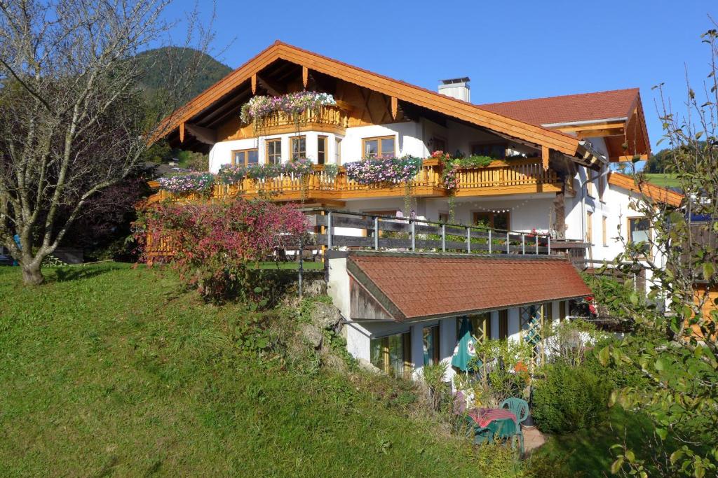 dom z balkonem na szczycie wzgórza w obiekcie Pension Berghof w mieście Brannenburg