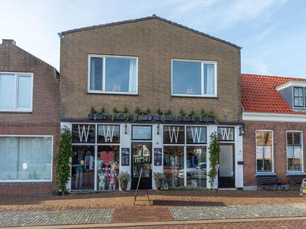 a brick building with windows and plants on it at Lovely, modern, 4-person apartment in the heart of Koudekerke in Koudekerke