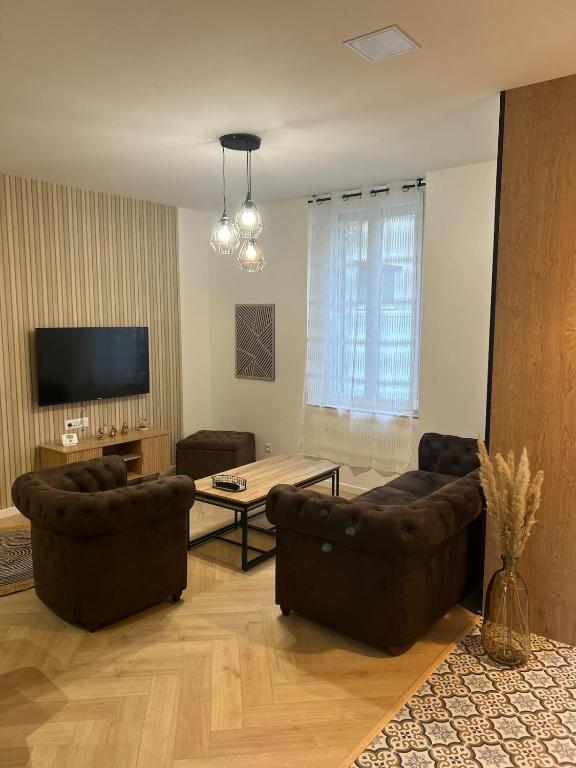 a living room with two couches and a table at Au papillon des coteaux in Magenta