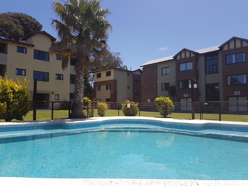 una piscina frente a unos edificios de apartamentos en Complejo Ostra Negra, en Valeria del Mar