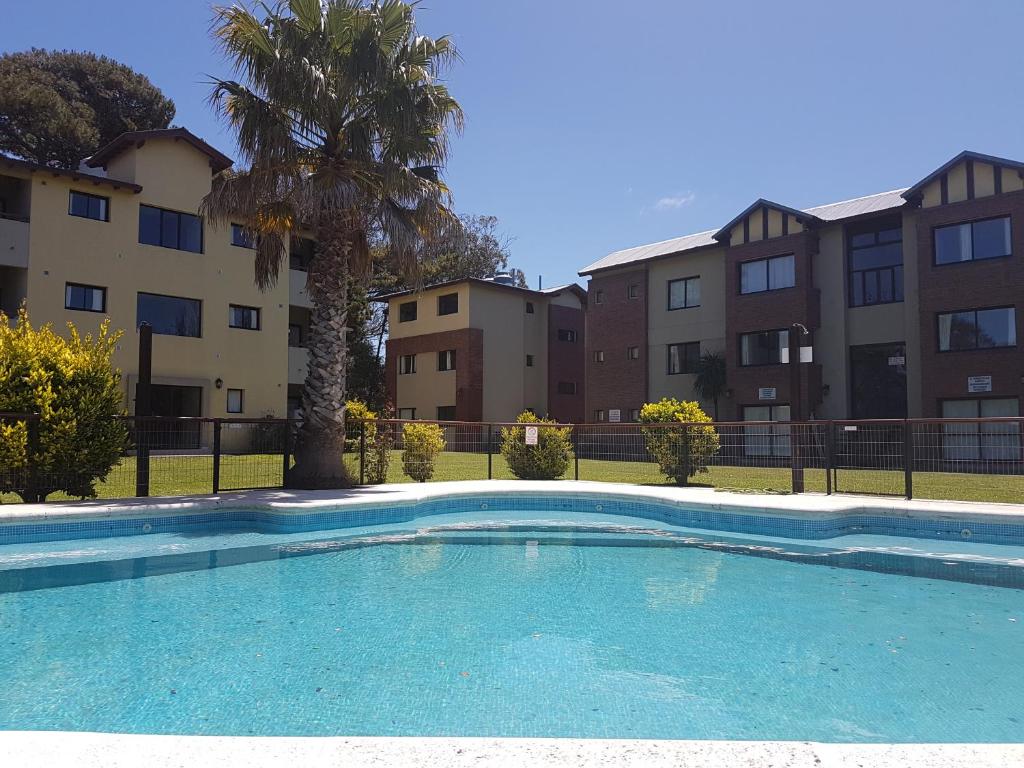 una piscina frente a algunos edificios de apartamentos en Complejo Ostra Negra en Valeria del Mar