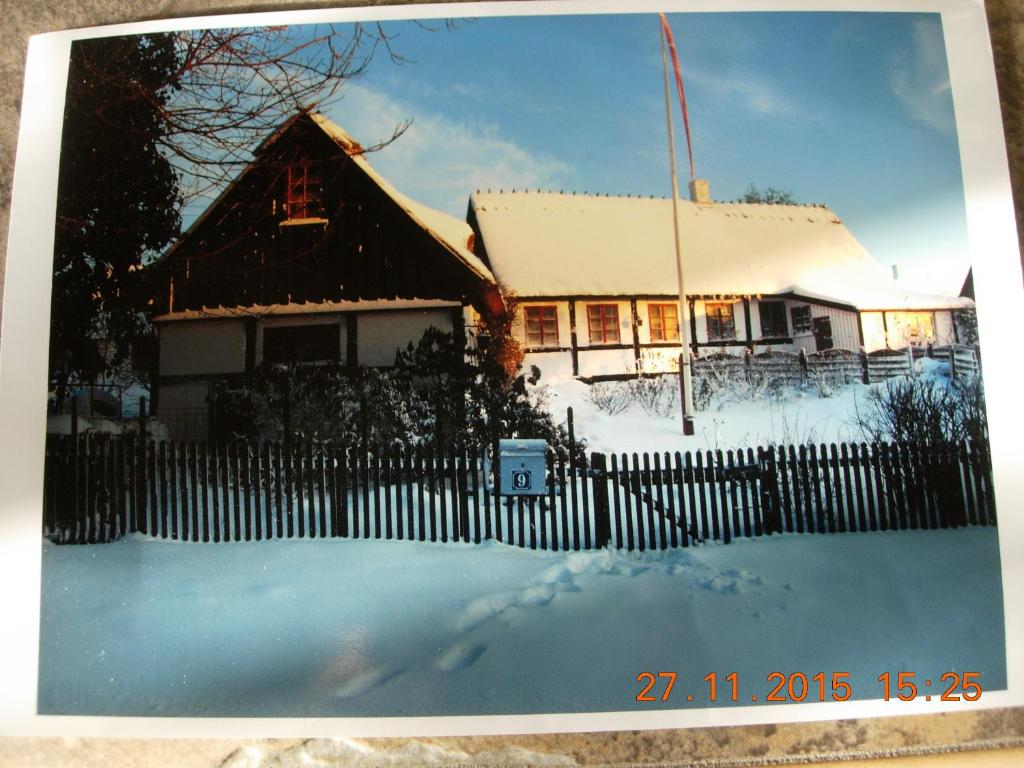a house with a fence in the snow at Travel back in time in Nyord