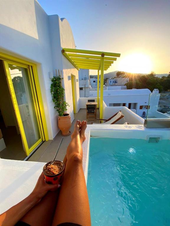 a person laying on the edge of a swimming pool at New Earth in Kamari