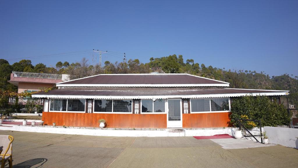 an orange and white building with a roof at Burj Resort in Ban