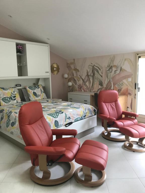 a bedroom with two red chairs and a bed at Super studio coup de cœur in Niort