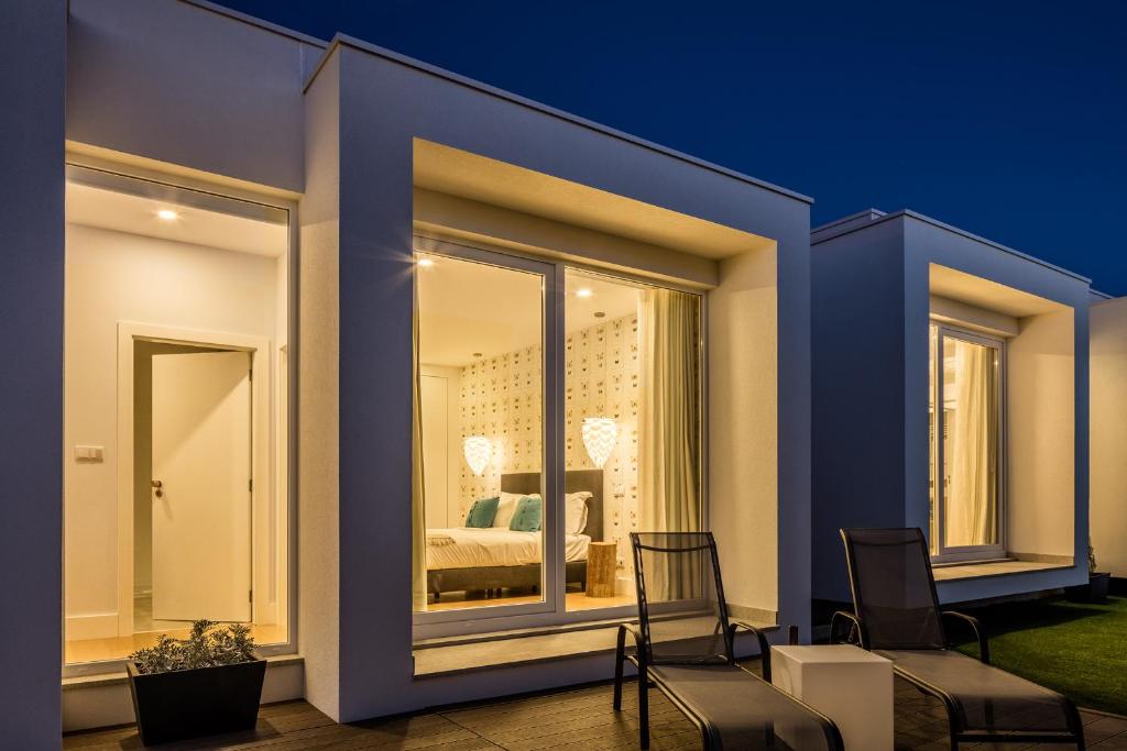 um p�tio com 2 cadeiras e um quarto ao fundo em Cerca Design House no Fund�o