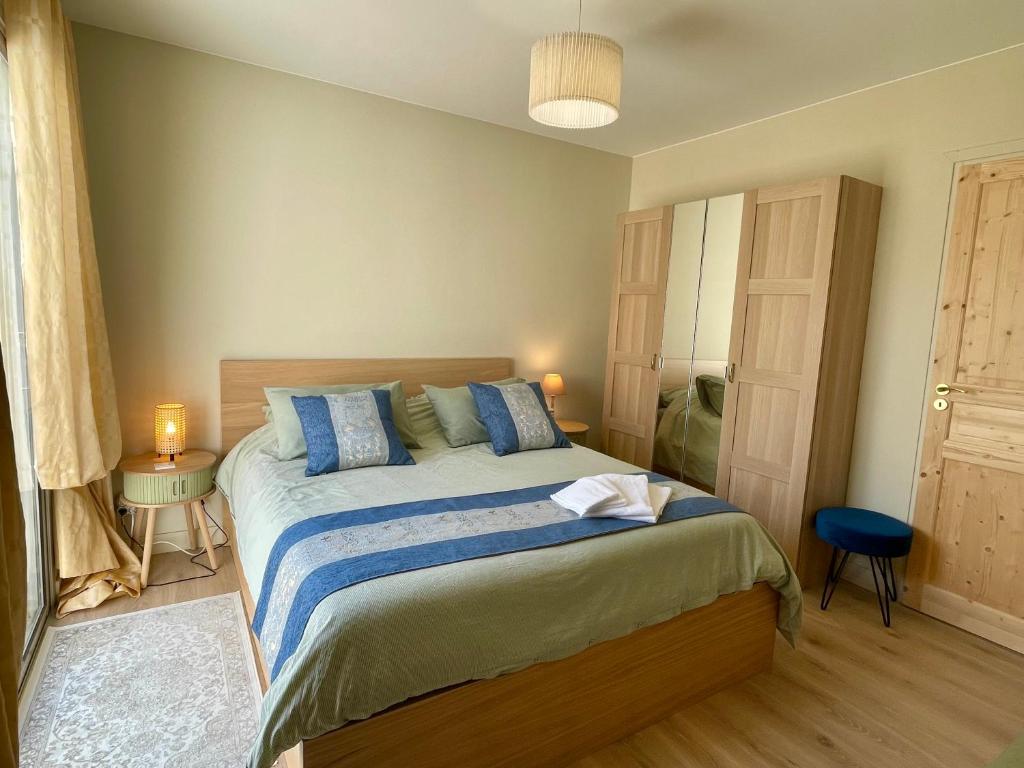 a bedroom with a large bed with blue pillows at Le temps des Pins in La Teste-de-Buch