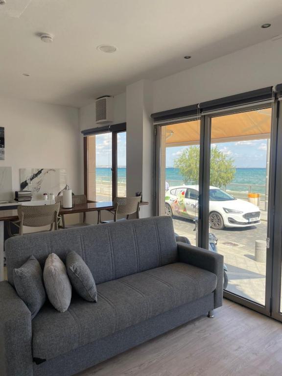 a living room with a couch and a view of the ocean at Seafront Home in Larnaca