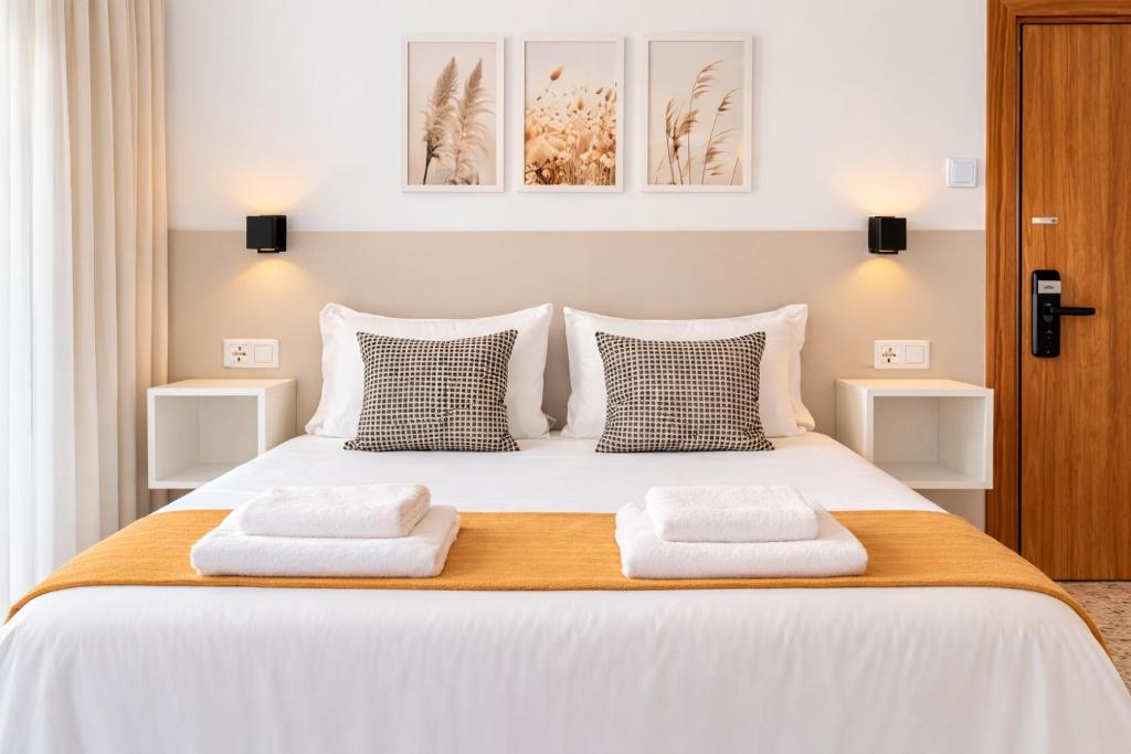 a bedroom with a large white bed with towels on it at Molí de Mar - Smart Hotel in Lloret de Mar