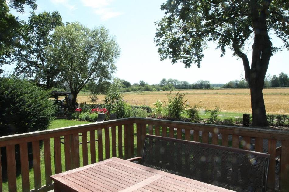 a wooden bench on a wooden fence with a view of a field at Abschalten und Kraft tanken im Wendland in Schreyahn