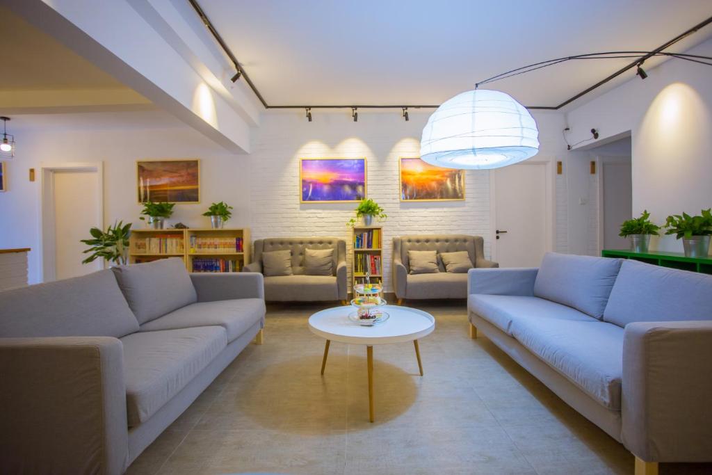 una gran sala de estar con sofás y una mesa. en Mekong At Home Homestay, en Jinghong