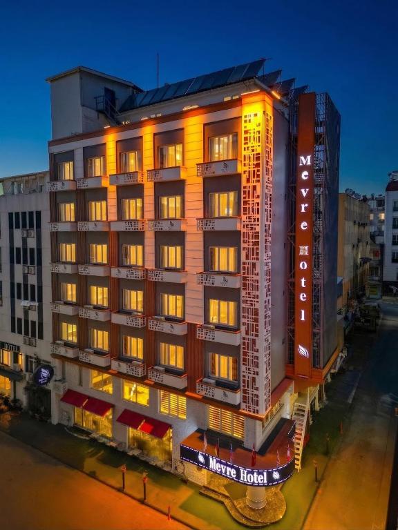 a tall building with lights on the side of it at Mevre Hotel in Antalya