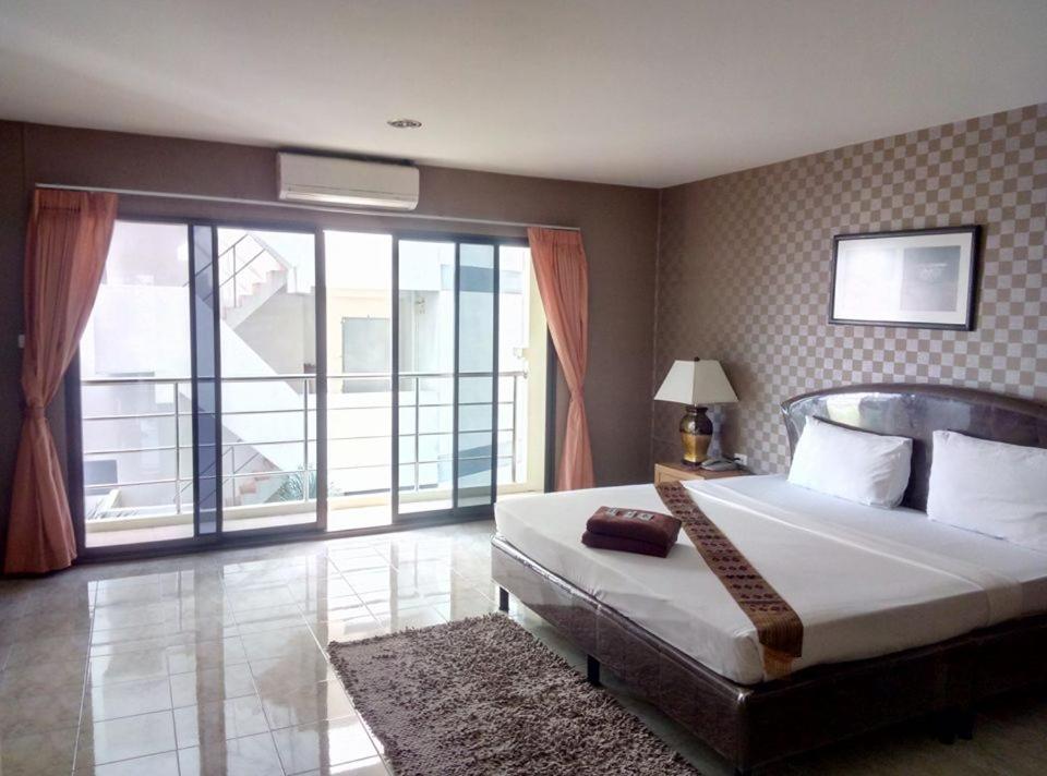 a bedroom with a large bed and a large window at Pearl Place Hotel in Hat Yai