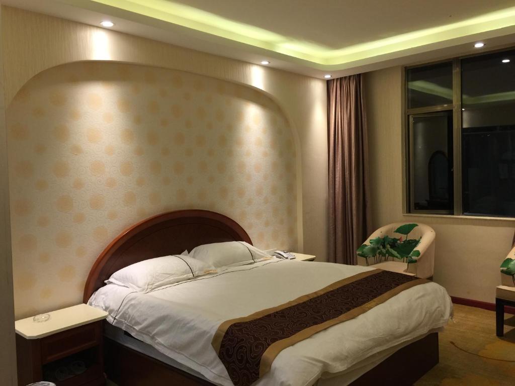 Postel nebo postele na pokoji v ubytování Bai Nian Sheng Shi Hotel