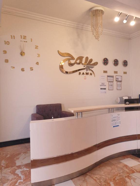 a lobby with a counter and a clock on the wall at سمح الضيافة in Ţubarjal