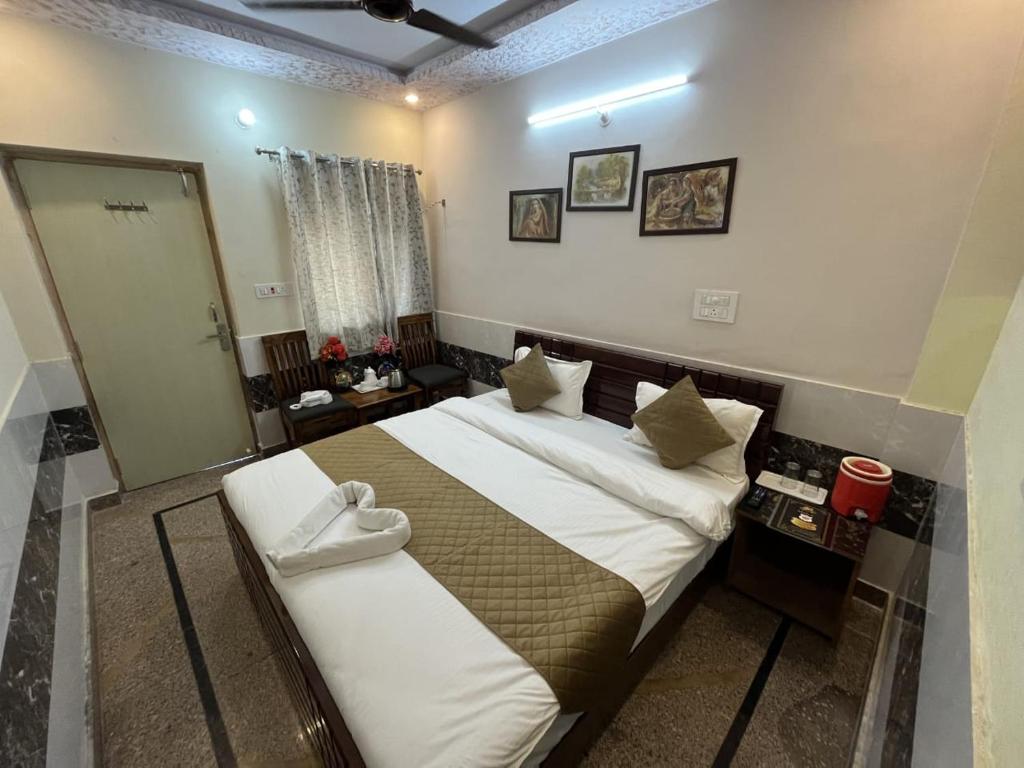 a bedroom with a large bed and a mirror at Hotel Srinivas in Jodhpur