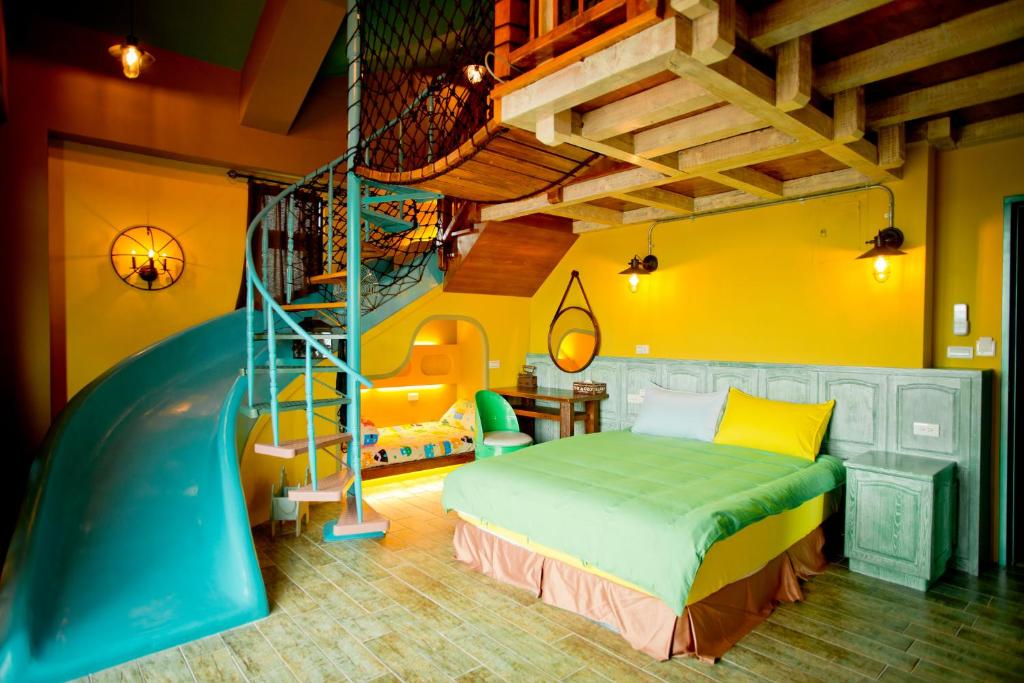 a bedroom with a bed and a spiral staircase at Kaho Homestay II in Hualien City