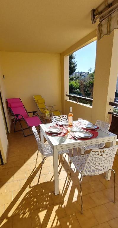 a white table and chairs in a room at A 2 pas du port, du centre, du marché provençal, des plages quartier calme in Sanary-sur-Mer
