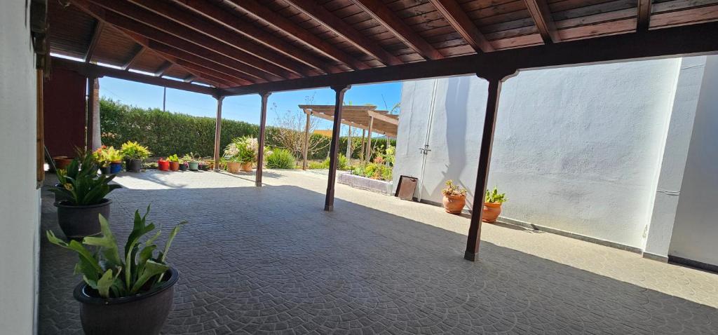 an outdoor patio with potted plants and a building at La Barbacoa in Dos Pinos