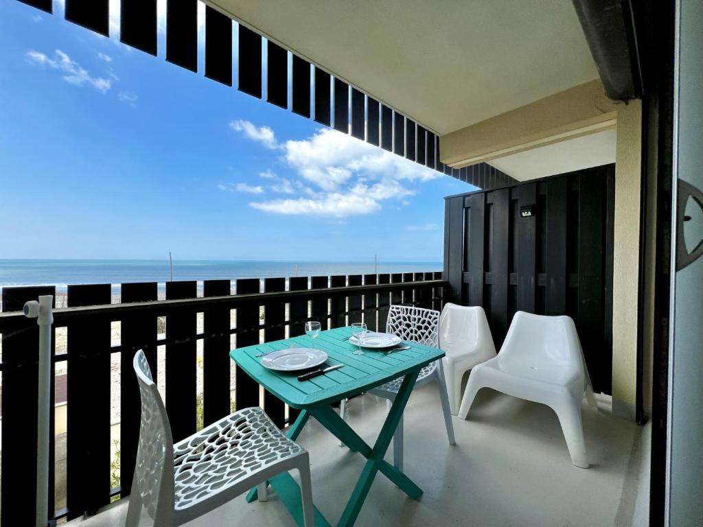 a balcony with a table and chairs and the ocean at Oceanide 72 by agence bru in Lacanau-Océan