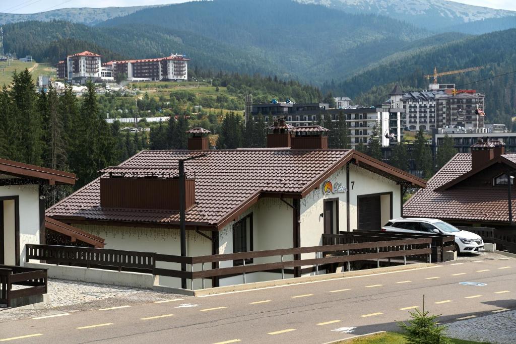 a house on the side of a road with a mountain at Die SONNE in Bukovel