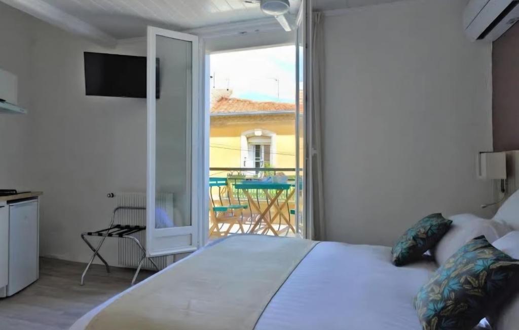 a bedroom with a bed and a balcony at Hôtel Archipel in Balaruc-les-Bains