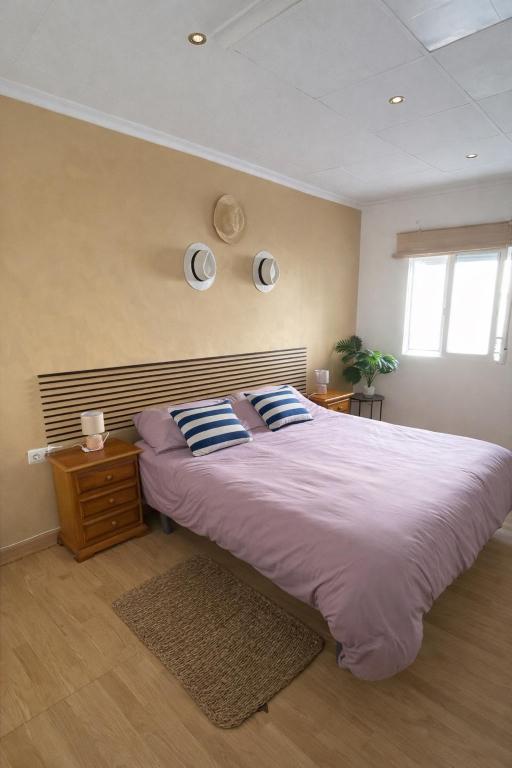 a bedroom with a large bed with blue and white pillows at Casa Caloret - Playa y centro a 2 min in Vinarós