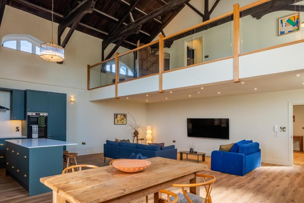 a living room with a wooden table and blue chairs at Luxury Riverside Duplex Apartment for 4 in Wilton