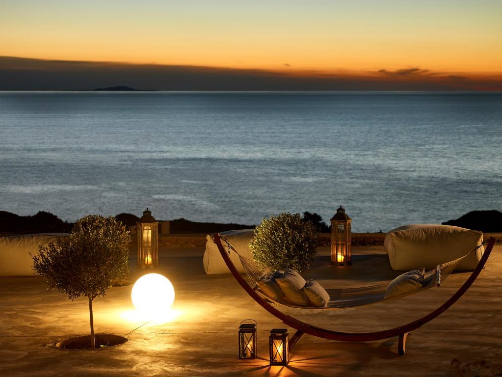 a hammock with a view of the ocean at sunset at Arpathea Villas in Foiníkion