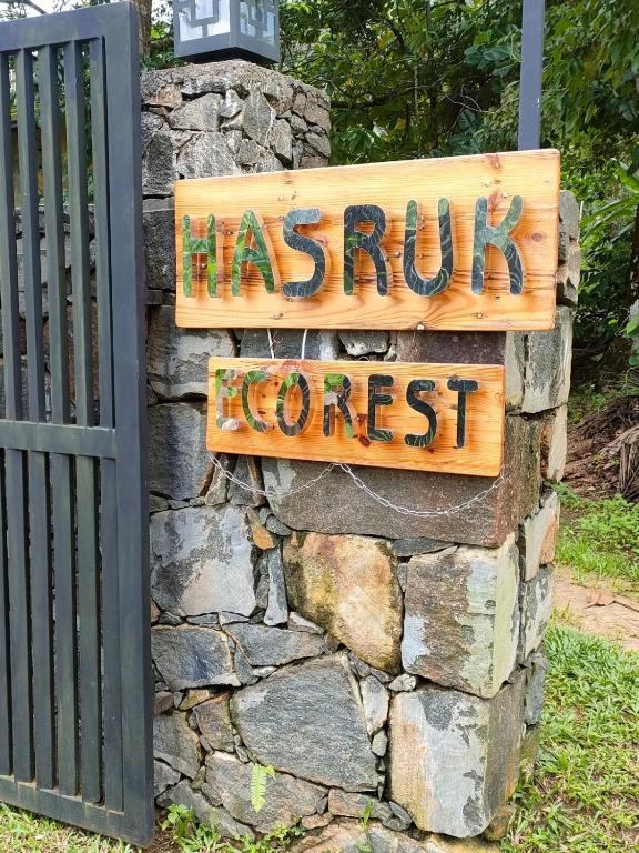a sign on top of a stone wall at Hasruk Eco Rest in Yatipauwa