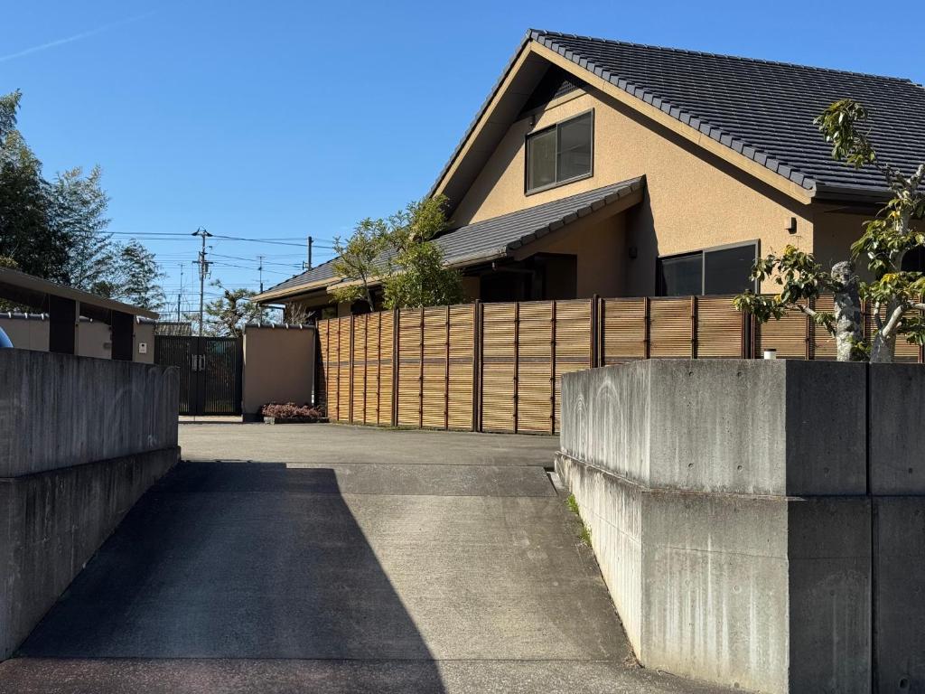 a fence in front of a house with a driveway at The Nine Kings in Imabari