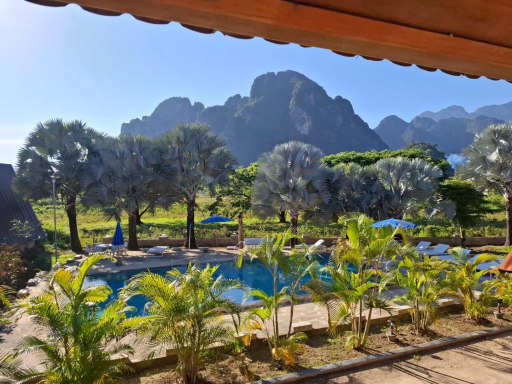 a view of a pool with mountains in the background at Romantic Vang Vieng resort in Vang Vieng