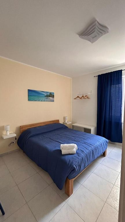a bedroom with a bed with a blue comforter at A Due Passi dal Centro in Favignana