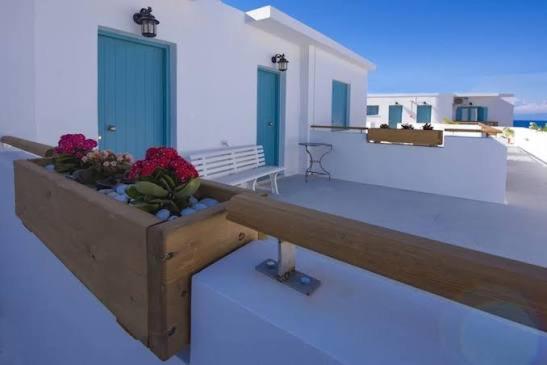 a planter with flowers on top of a balcony at Little Blue Doors Studios in Samos