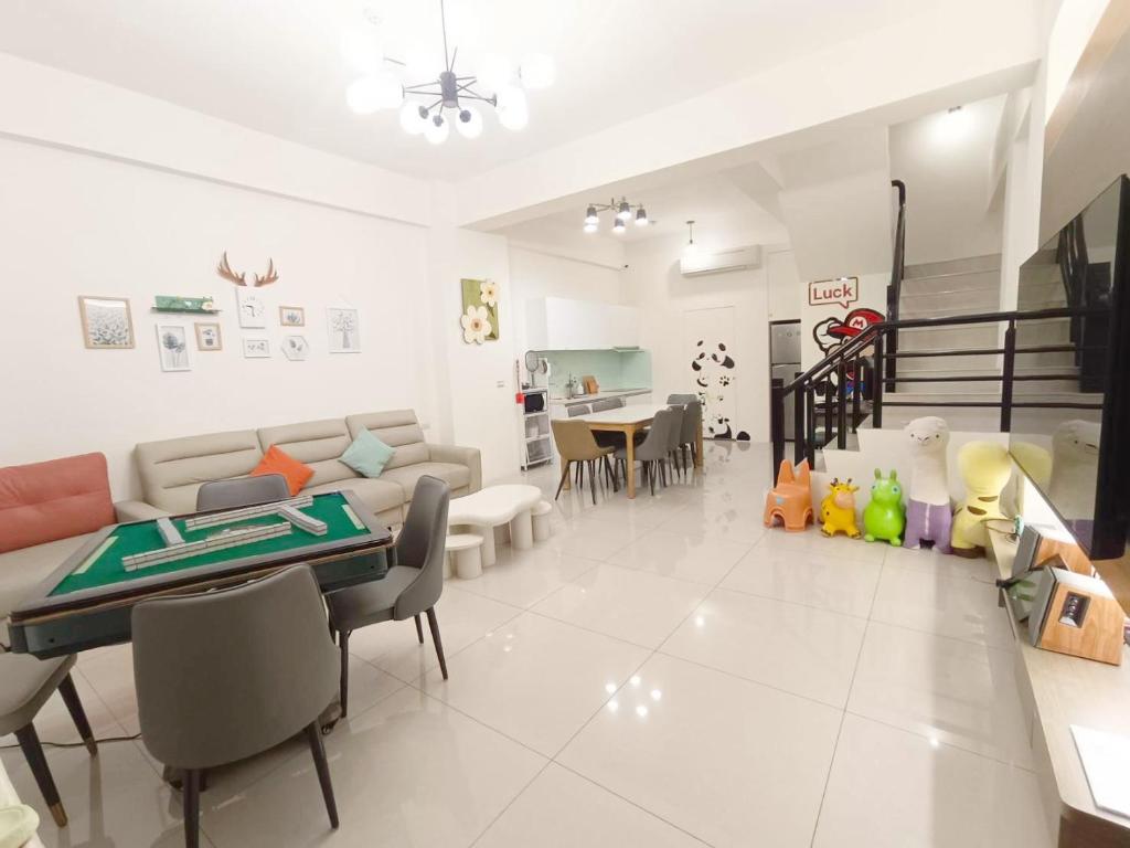 a living room with a couch and a table and chairs at Aidao B&B in Dazhou